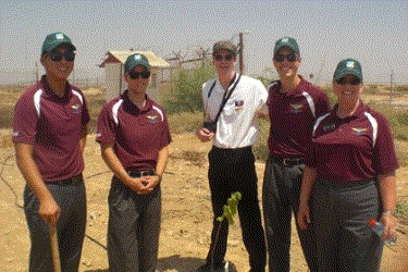 Group of airforce cadets with a freshly planted tree.
